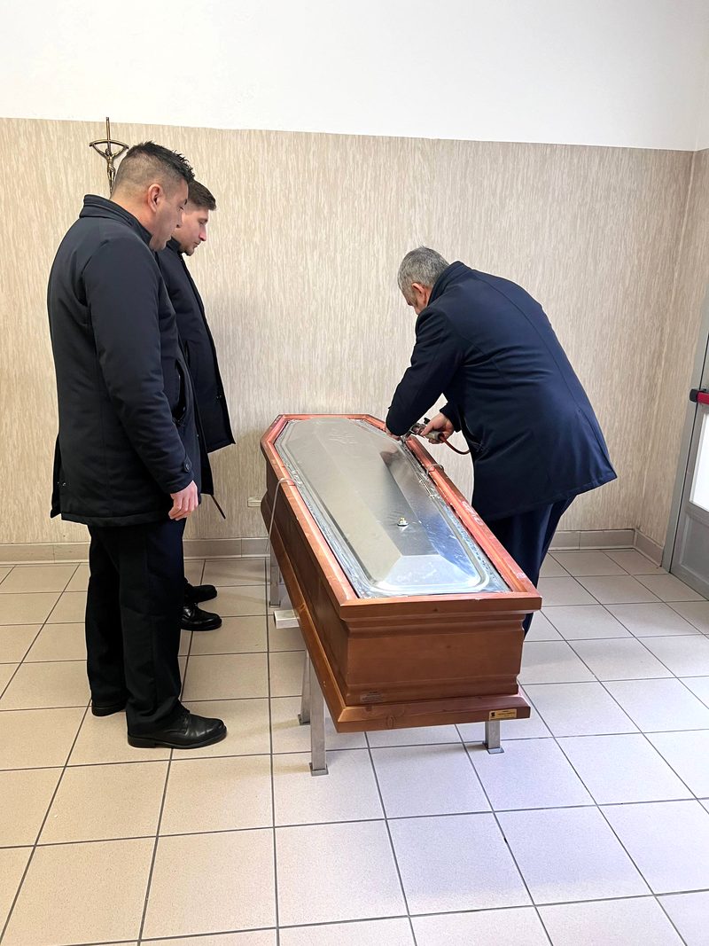 Фахівці ритуальної служби герметизують цинковий вкладиш труни у залі прощання